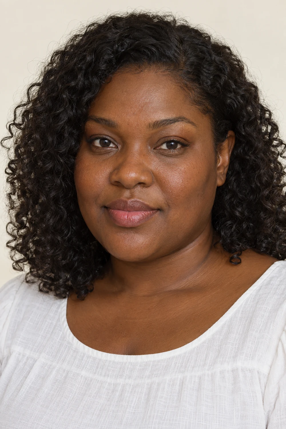 A fictional woman with deep warm brown skin and dark curls wearing a compact bronze outer-lash trace and rose satin lips with a white blouse.